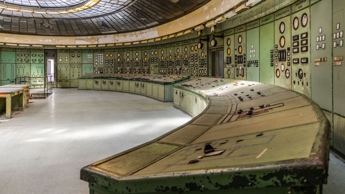 Retro industrial control room with vintage panels and dials in an old power plant.