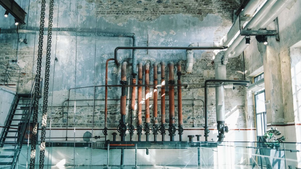 Rustic industrial scene featuring vintage pipes and brick walls in an old warehouse setting.
