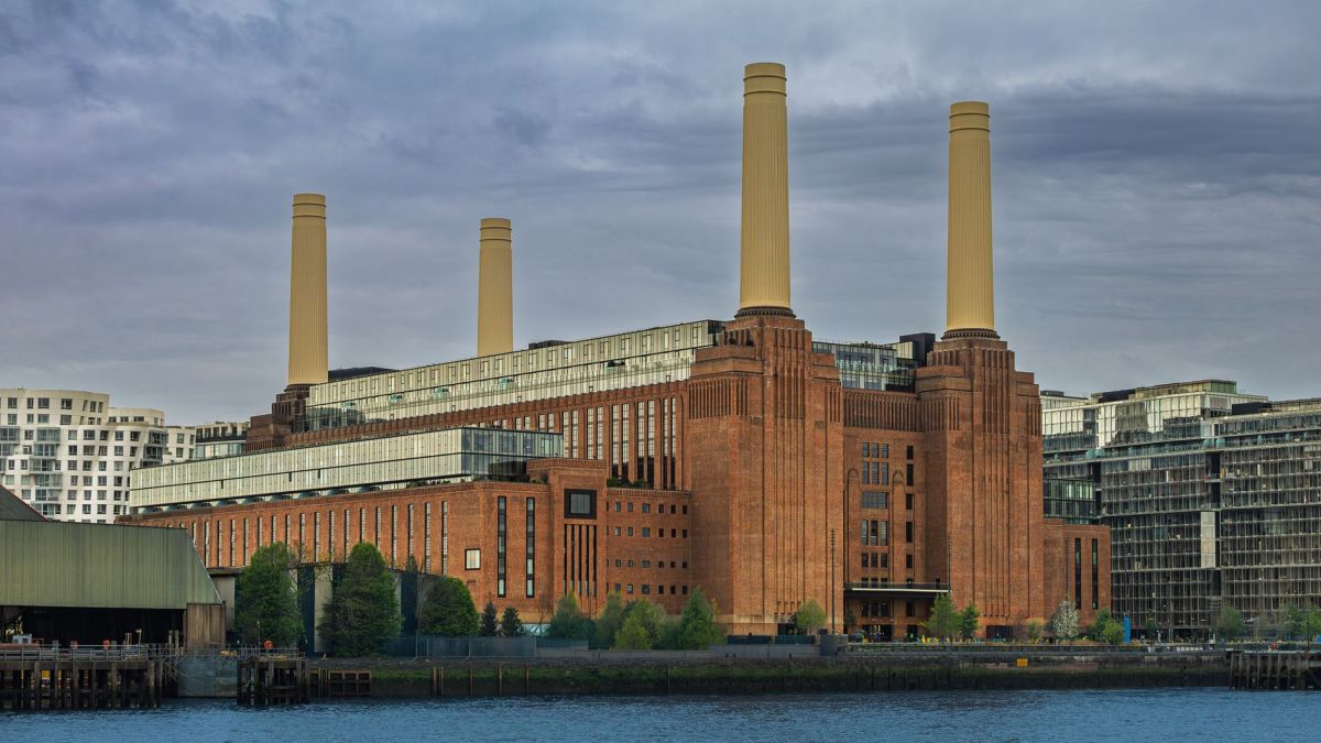 Iconic Battersea Power Station by the Thames in London under a cloudy sky.
