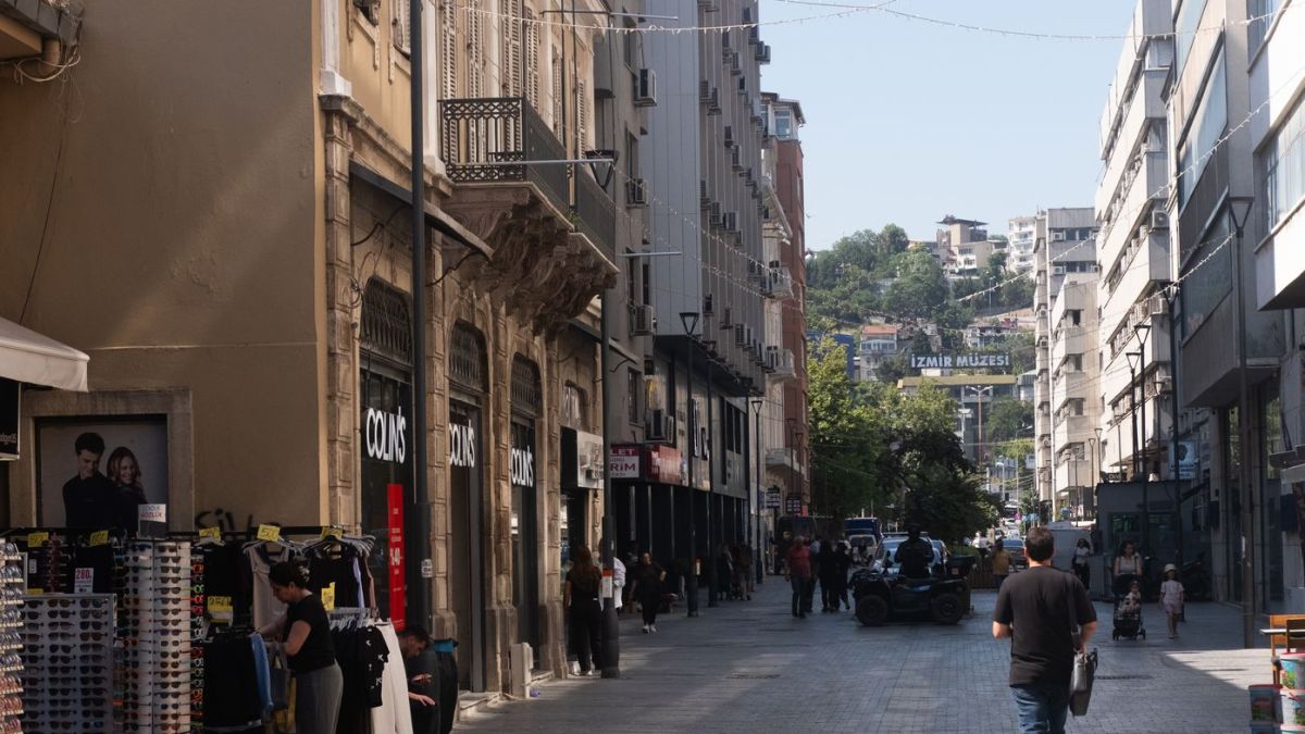 Lively pedestrian street in İzmir, Türkiye with shops and people enjoying the day.