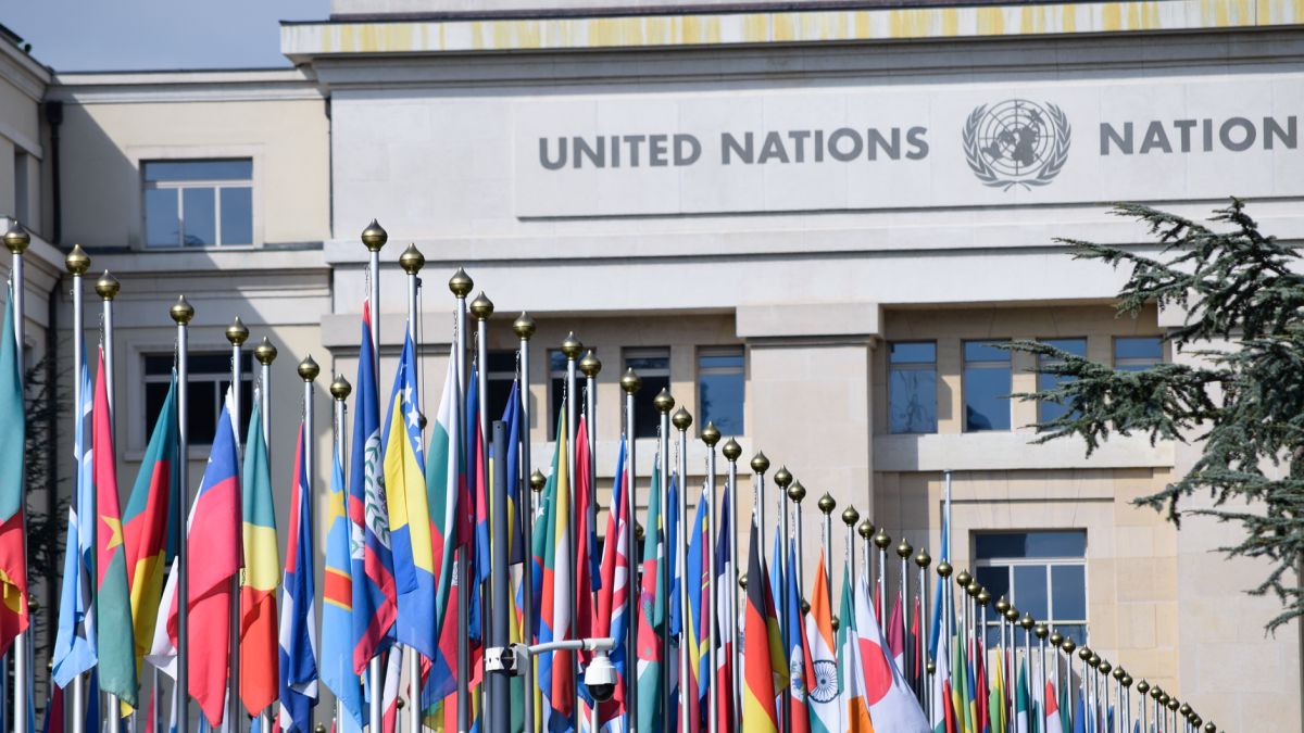 Colorful flags outside the United Nations office in Geneva, symbolizing global unity.