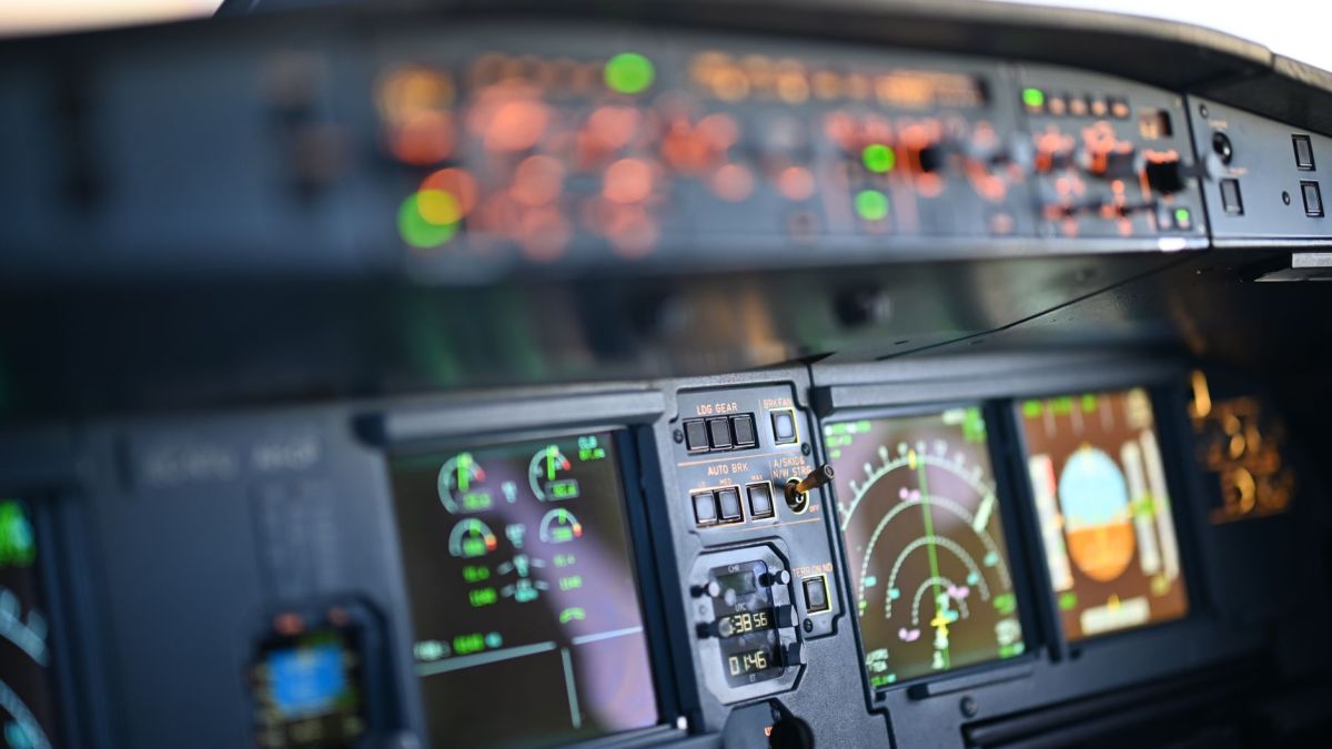 Close-up view of airplane cockpit instrumentation with modern digital displays.
