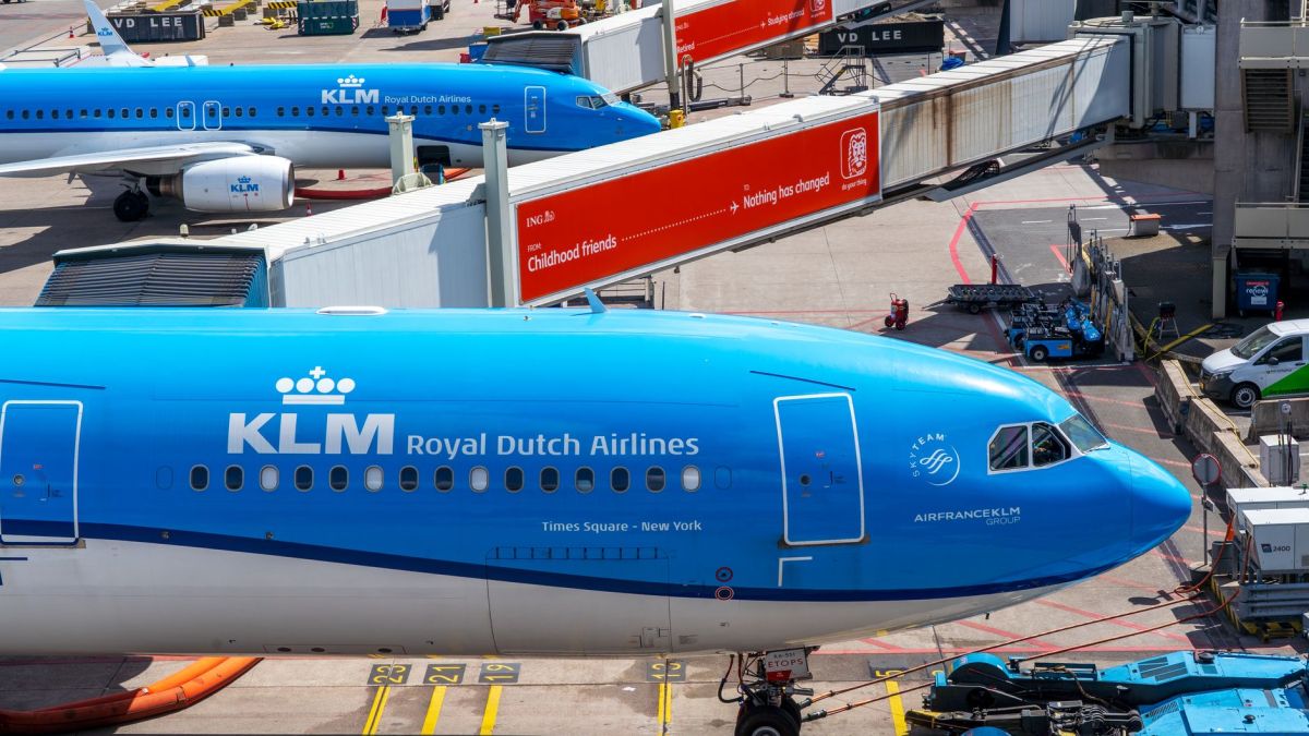 KLM Royal Dutch Airlines planes at airport gate, bustling aircraft activity.