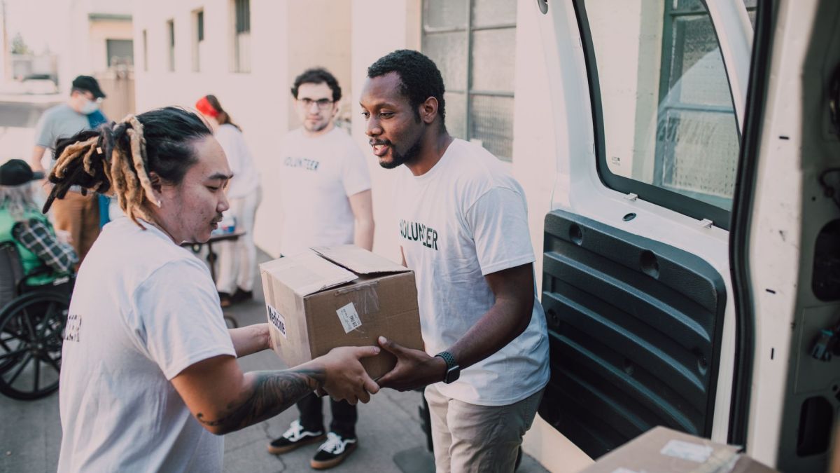 Volunteers working together to distribute donated supplies from a van.