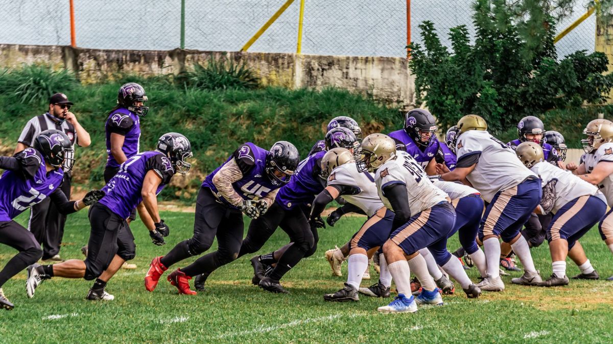 Players in action during an American football game on a grassy field.
