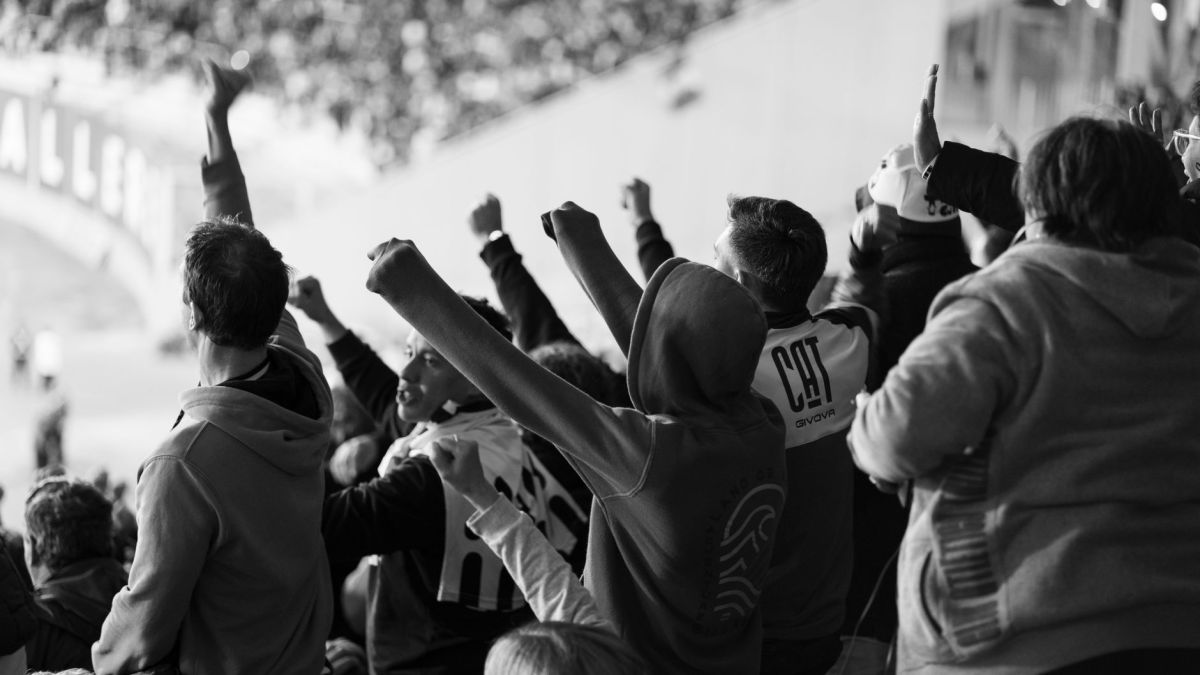 A crowd of enthusiastic football fans cheering inside a stadium in Córdoba, Argentina.