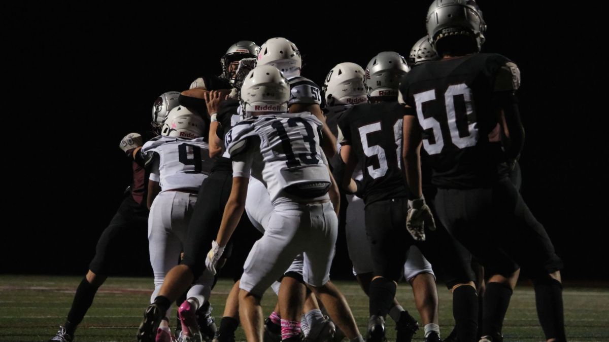 Exciting nighttime football match in Farmington, Connecticut showcasing teamwork and action.