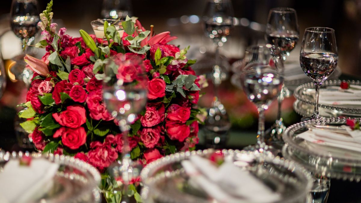 A beautiful table setting featuring red roses and crystal glassware for a sophisticated event.