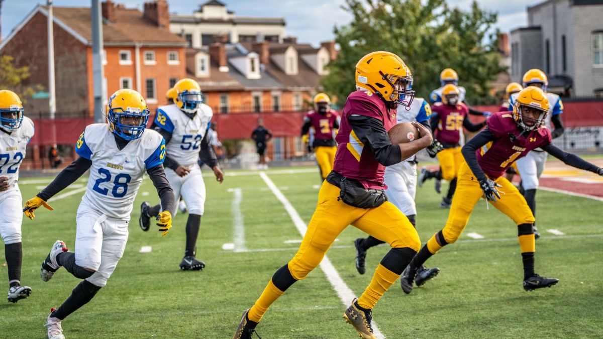 A thrilling moment in an American football game with players in action on a Baltimore field.