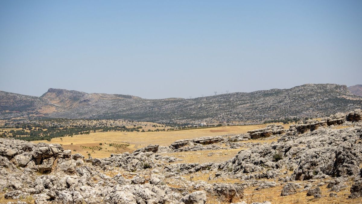 Explore the rugged terrain and rocky landscapes of Çermik, Türkiye, under a clear summer sky.