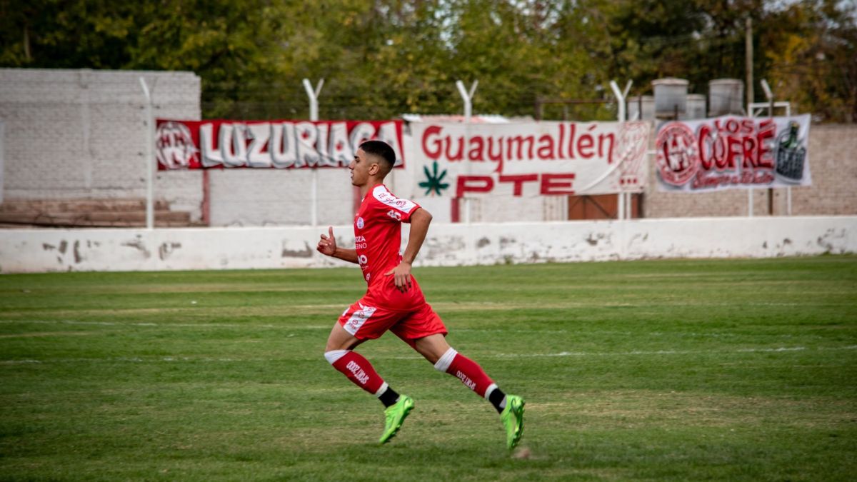 Dynamic shot of a young soccer player running on a football field during a match.