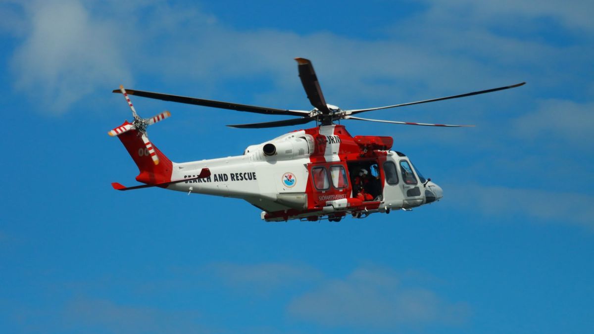 Helicopter flying in blue sky during a search and rescue operation in Sweden.