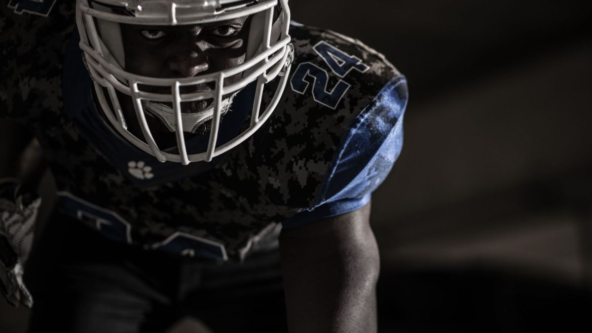 Intense close-up of a focused American football player ready for action on the field.