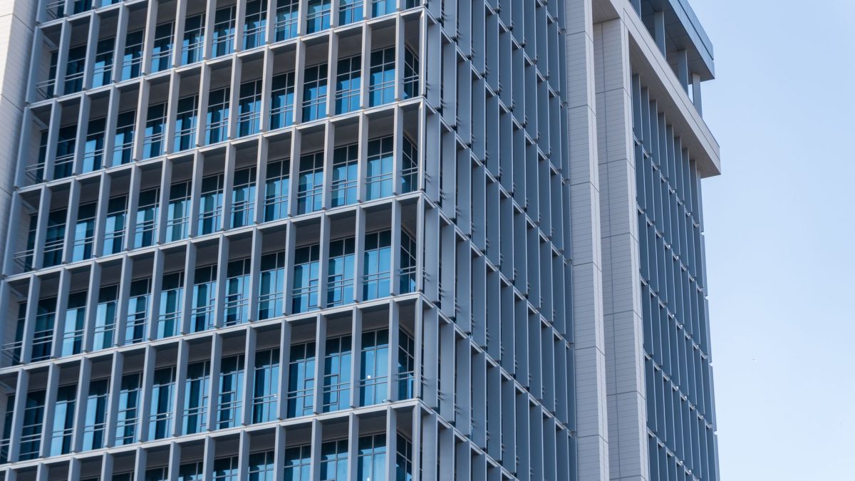 Exploring the sleek design of a modern high-rise office building featuring a glass facade.