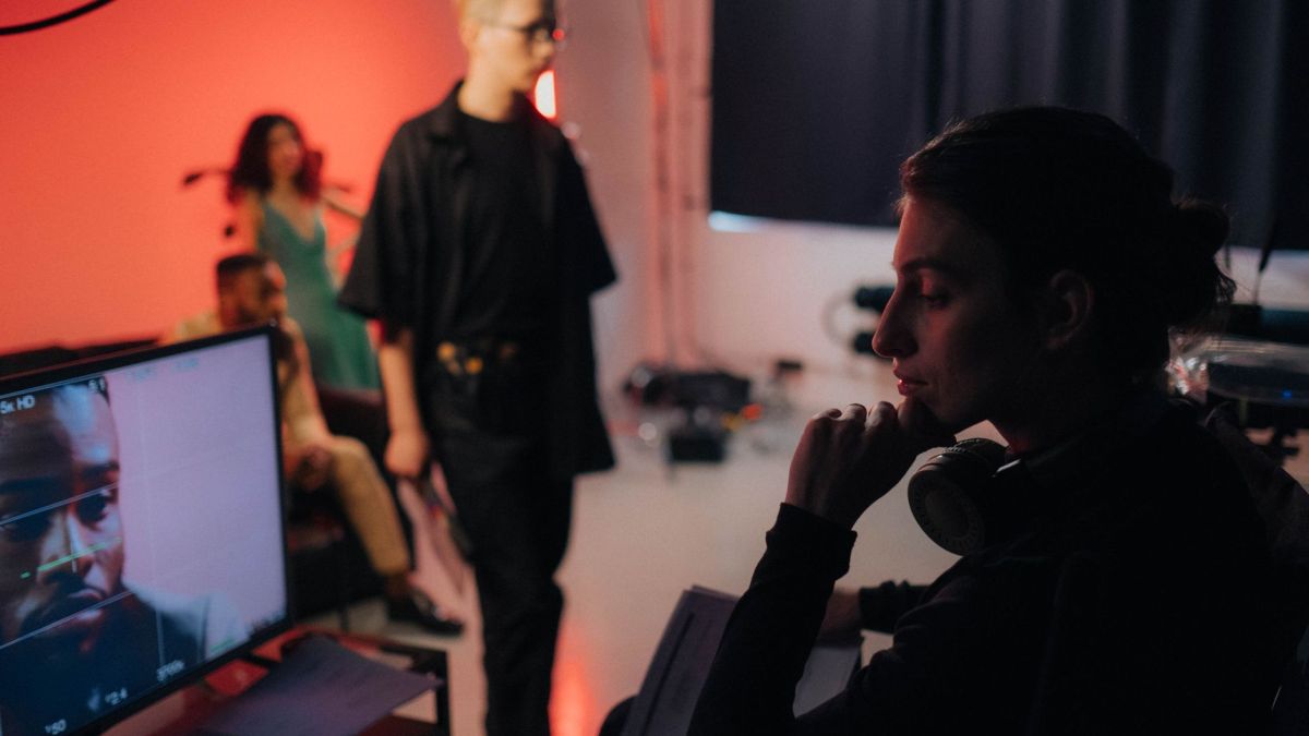 Creative professionals collaborating on a dynamic studio set with vibrant lighting.