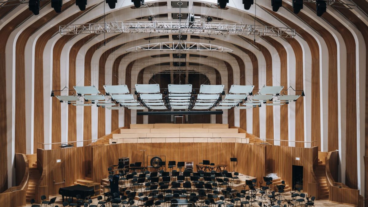 Spacious modern auditorium featuring wooden interior architecture and empty seating.