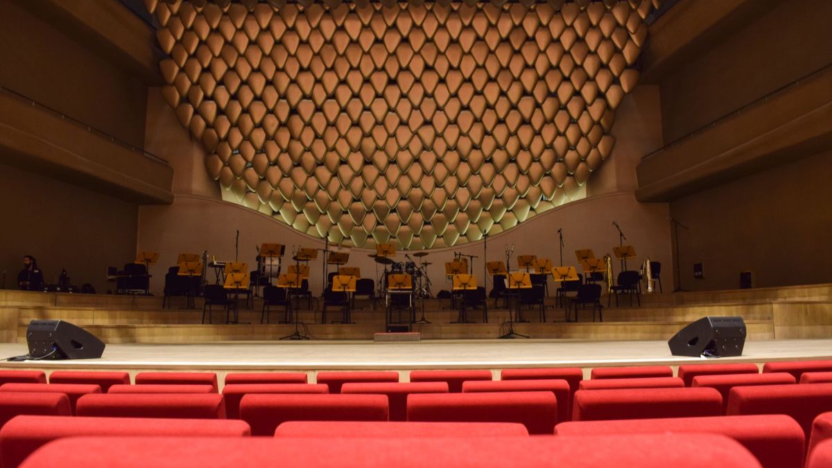 Elegant concert hall interior with empty seats and stage, ready for performance.