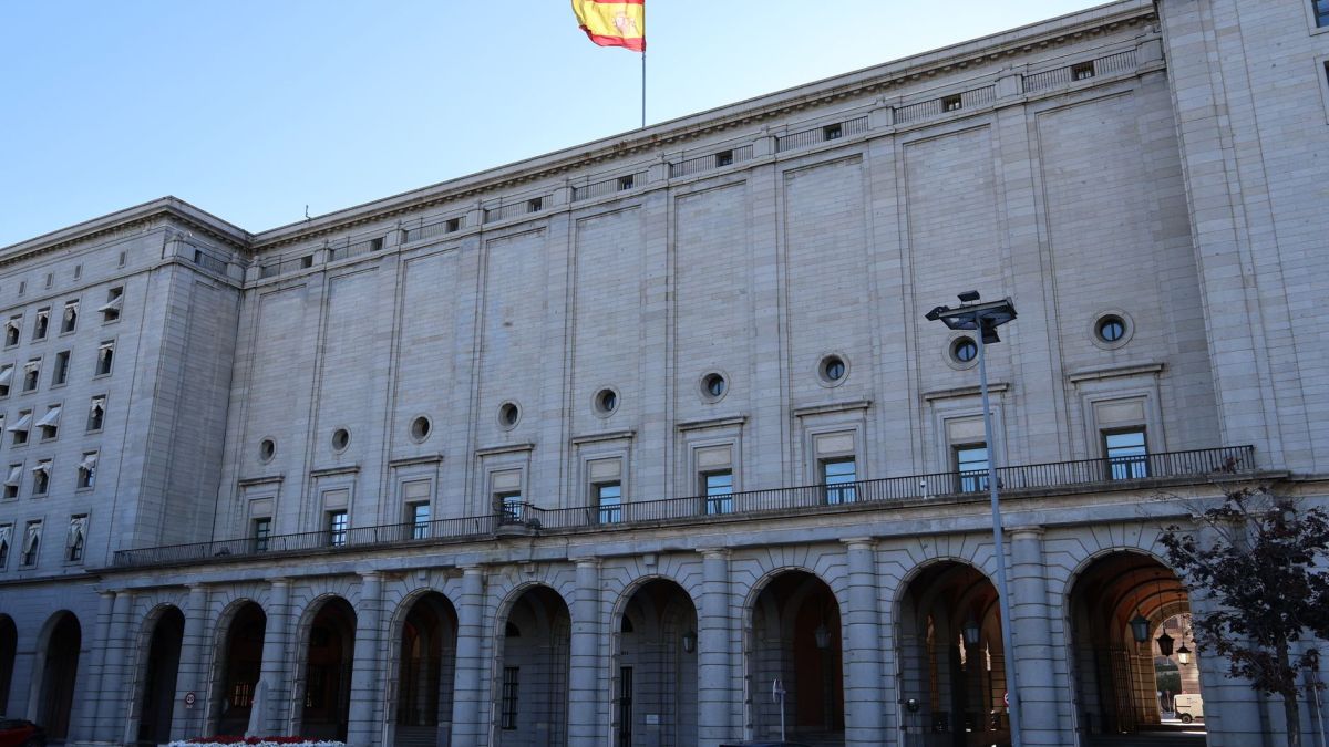 Exterior of a historic government building in Spain with a Spanish flag atop.