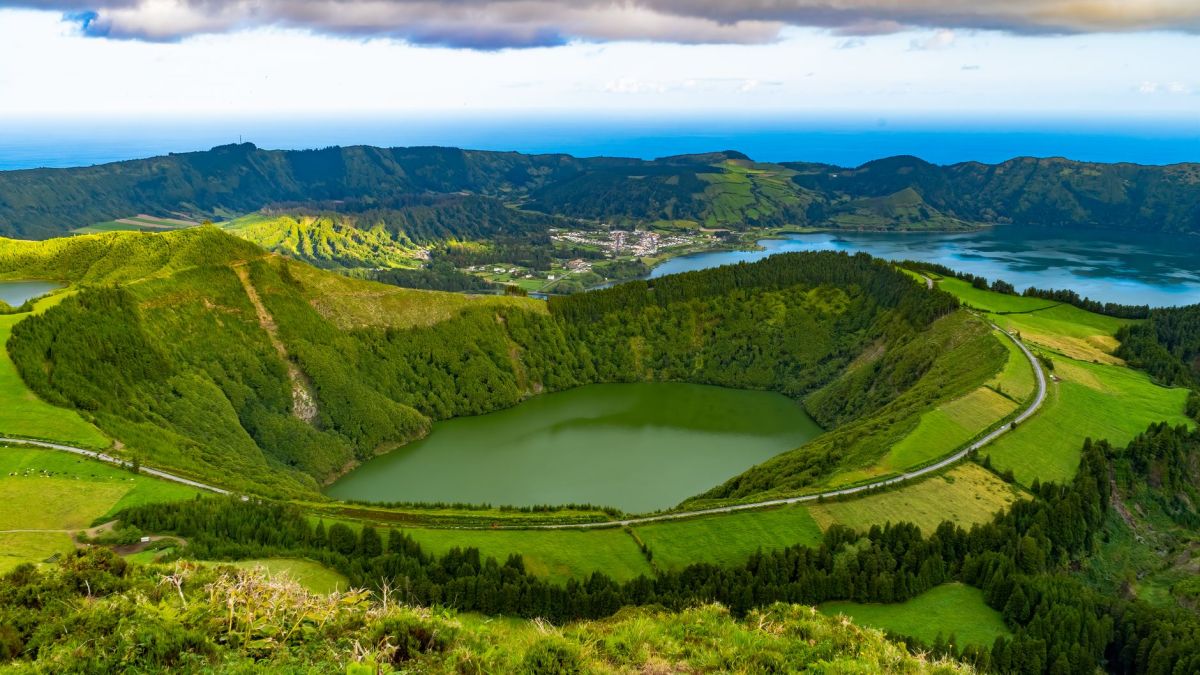 Explore the breathtaking view of lush green caldera landscapes in the Azores, Portugal with serene lakes and rolling hills.