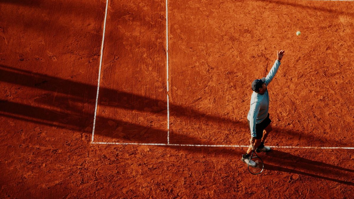 Aerial view of a tennis player serving on a clay court in Buenos Aires, Argentina.