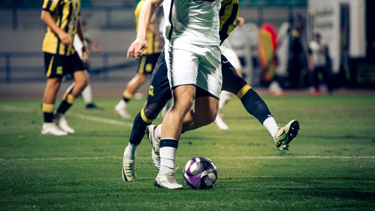 Close-up of soccer players in action during a match at an outdoor stadium.