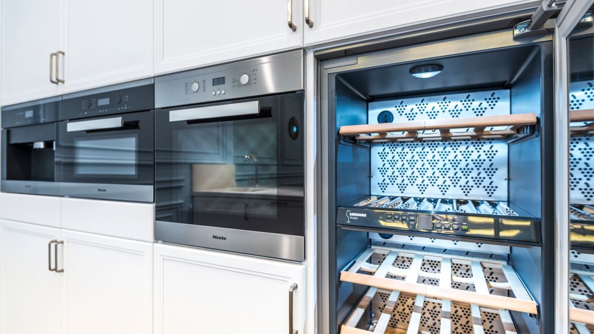 Elegant modern kitchen featuring built-in ovens and a wine cooler with stylish cabinetry.