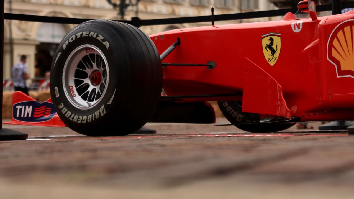 Close-up shot of a red Formula 1 racing car with visible brand logos and Bridgestone tire.