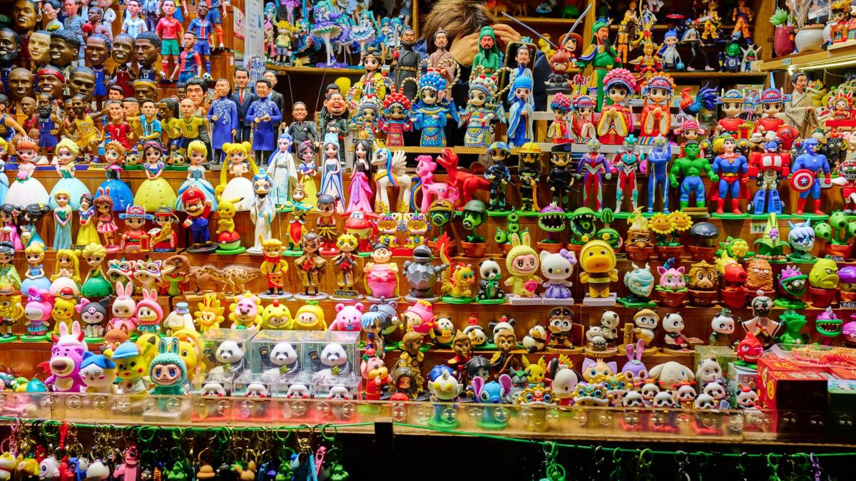Colorful array of figurines and toys displayed on shelves in a shop, showcasing diverse characters.