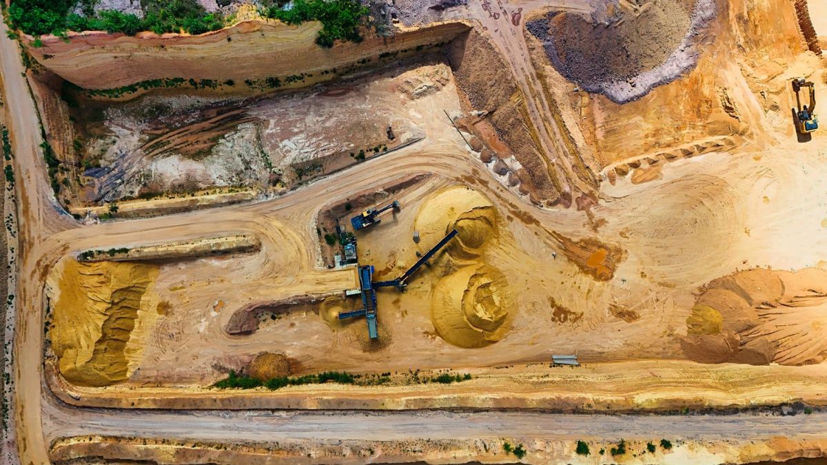 Aerial shot of a quarry with machinery extracting and processing materials.