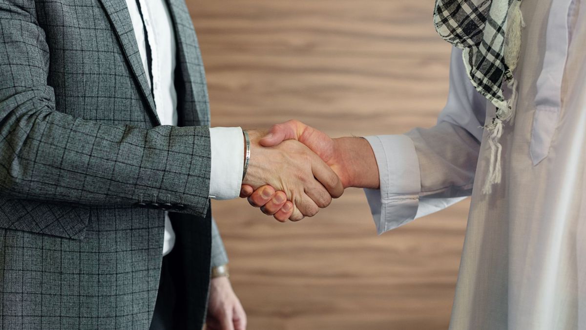 Close-up of a handshake between two men in business attire, symbolizing cooperation and partnership.