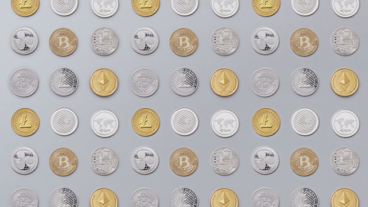 A seamless pattern of various cryptocurrency coins in gold and silver tones.