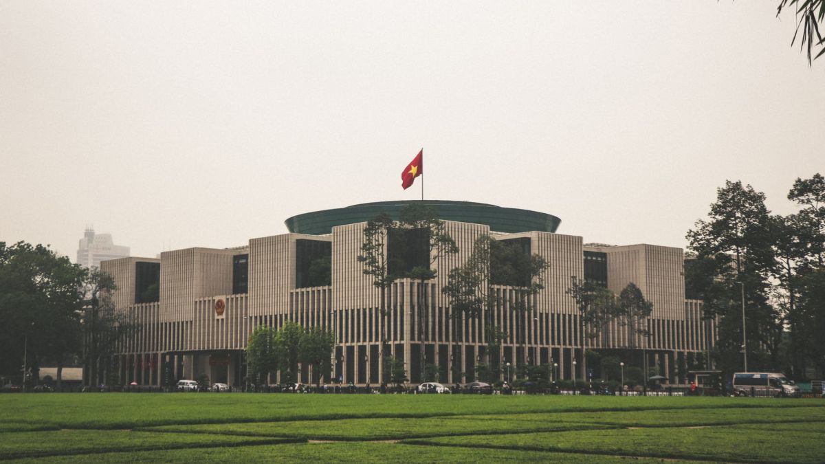 View of the Vietnam National Assembly Building in Hanoi with Vietnamese flag.