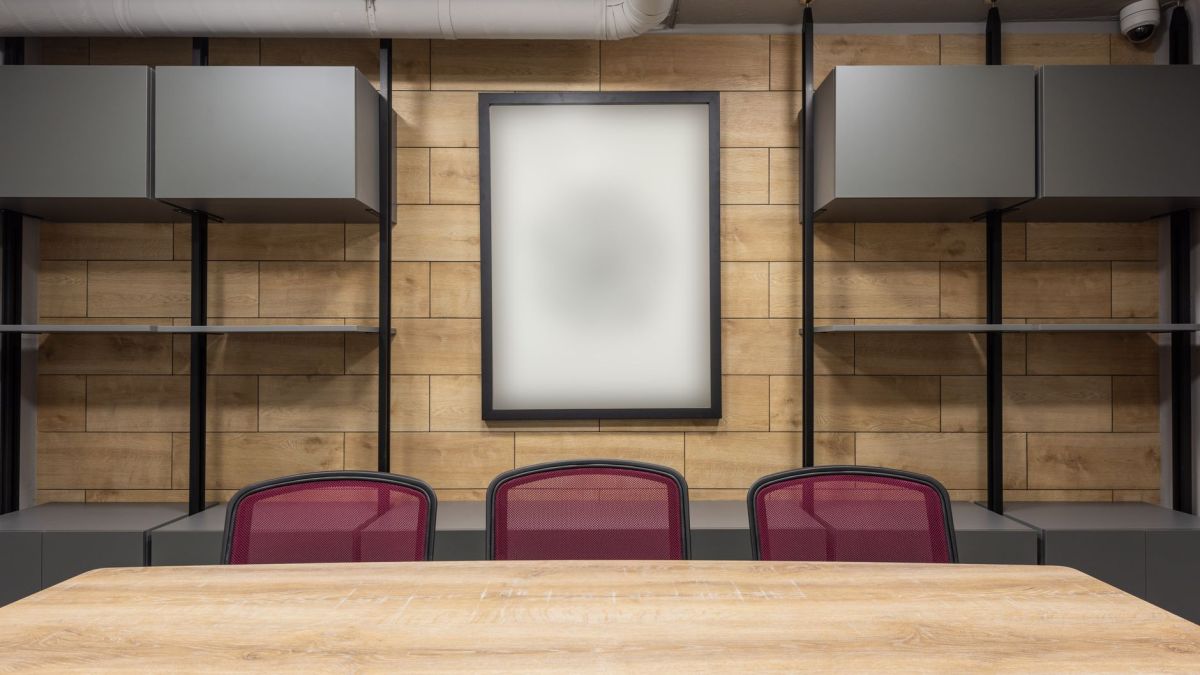 Contemporary interior of new boardroom equipped with wooden table and red office chairs