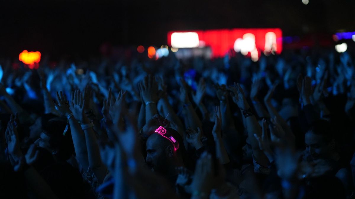A lively concert scene with a crowd of people enjoying the music at night.