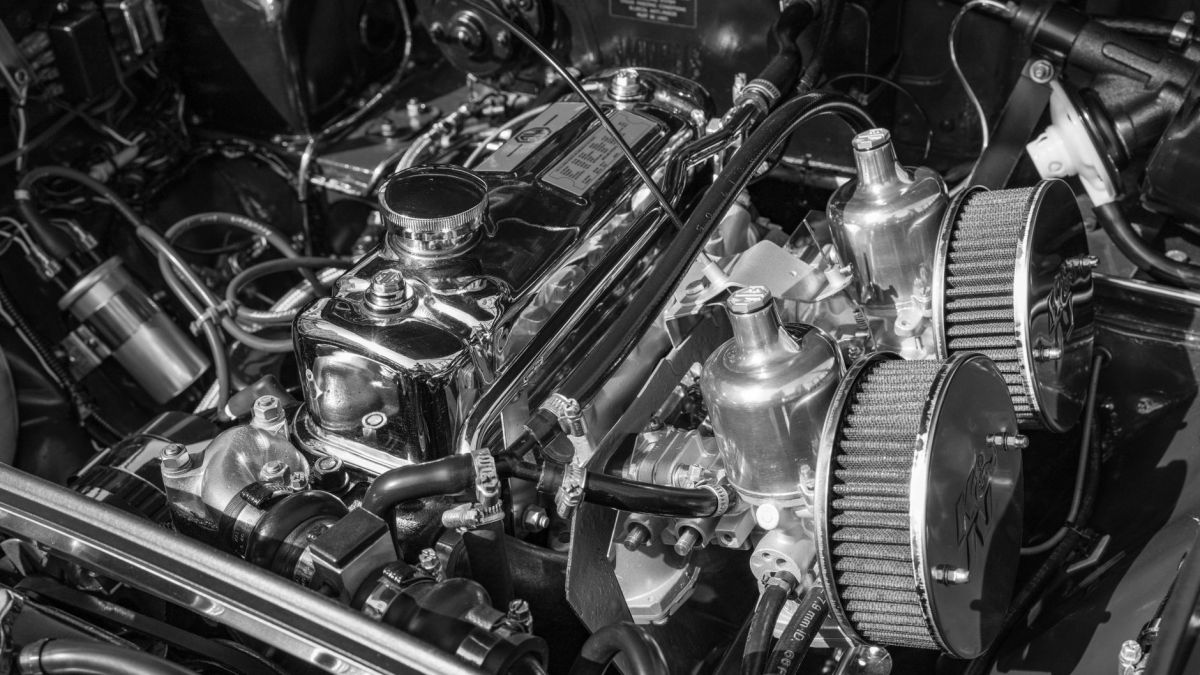Detailed close-up of a classic car engine, highlighting chrome and mechanical components.