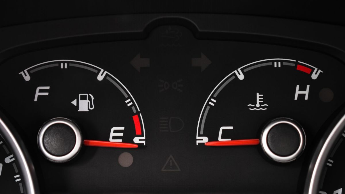 Detailed view of a car's fuel and temperature gauges on dashboard.