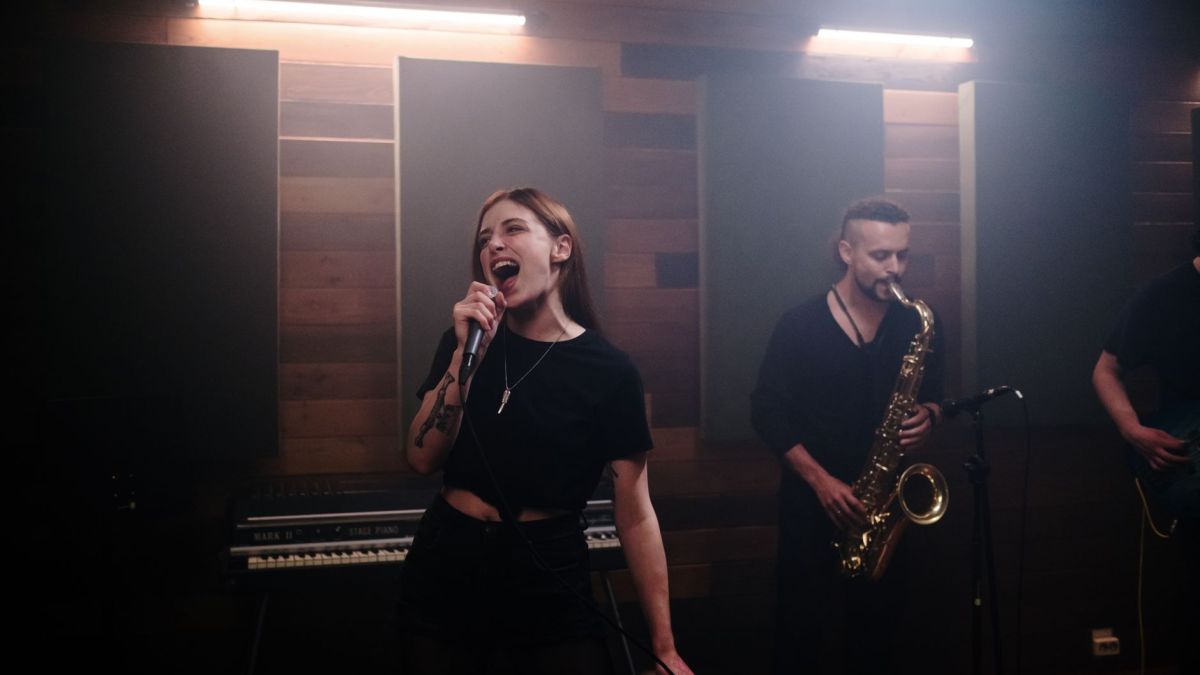 Energetic music band performing live in a recording studio with vocalist and saxophonist.