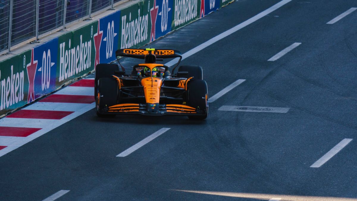 A Formula 1 racing car speeding along the Baku City Circuit during a race event.
