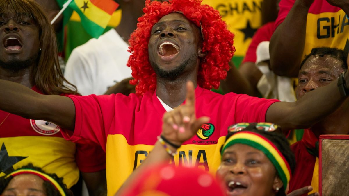 Ghanaian soccer fans passionately cheering during a match, showcasing national pride.