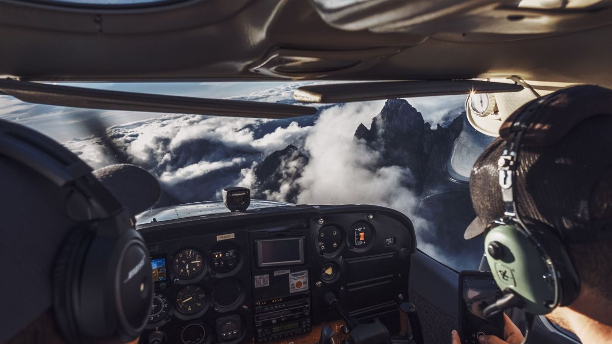 Pilot's perspective of flying over clouds and mountains, capturing the breathtaking view.