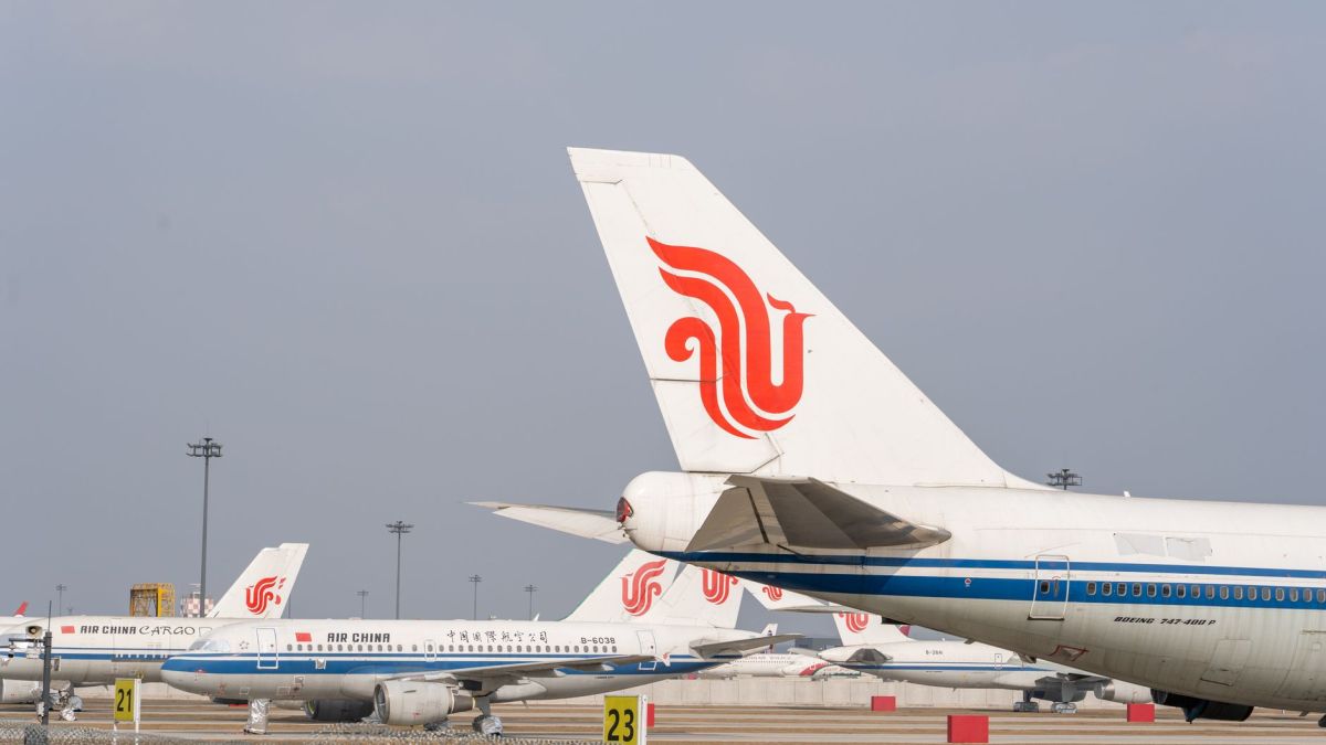 Multiple Air China aircraft lined up on an airport runway, clear sky backdrop.