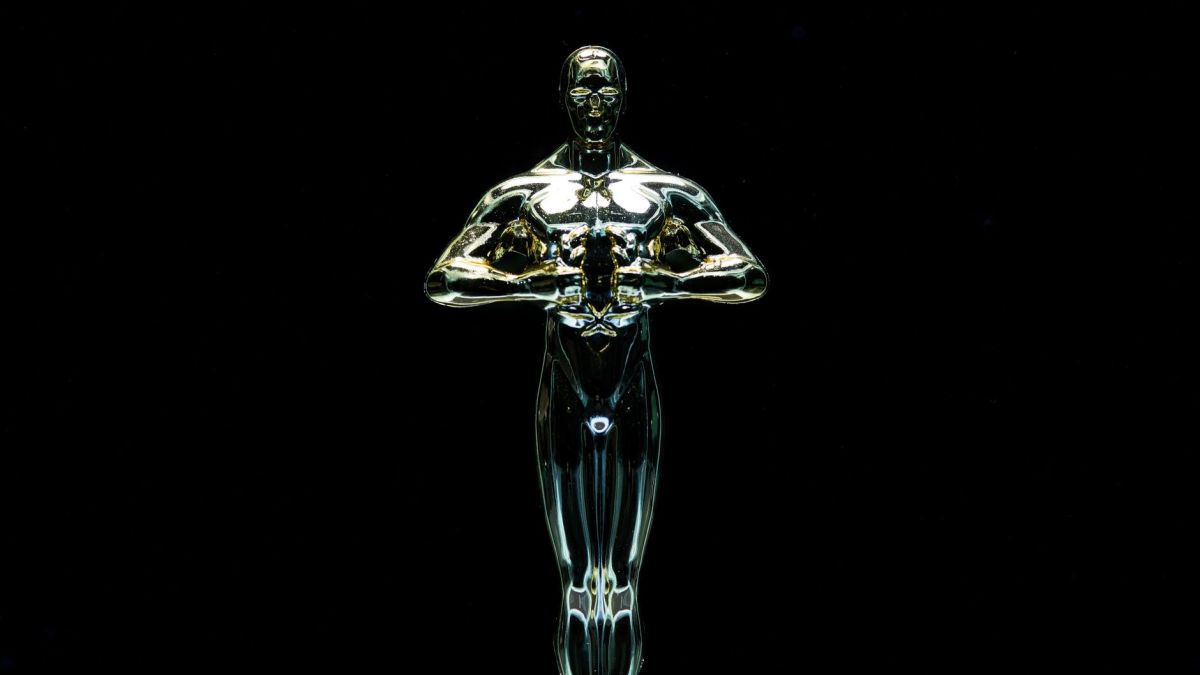 A golden trophy statue isolated on a black background symbolizing achievement and victory.