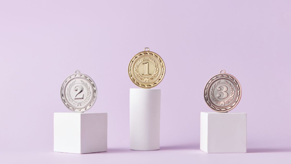 Medals on a podium against a soft pastel background, ideal for awards themes.