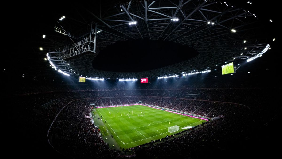 Aerial view of a night football match in Budapest. Illuminated stadium full of fans adds dramatic atmosphere.