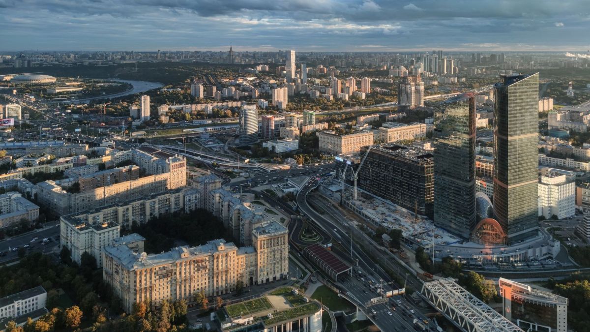 A breathtaking aerial view of a bustling modern cityscape with skyscrapers and roads at dusk.