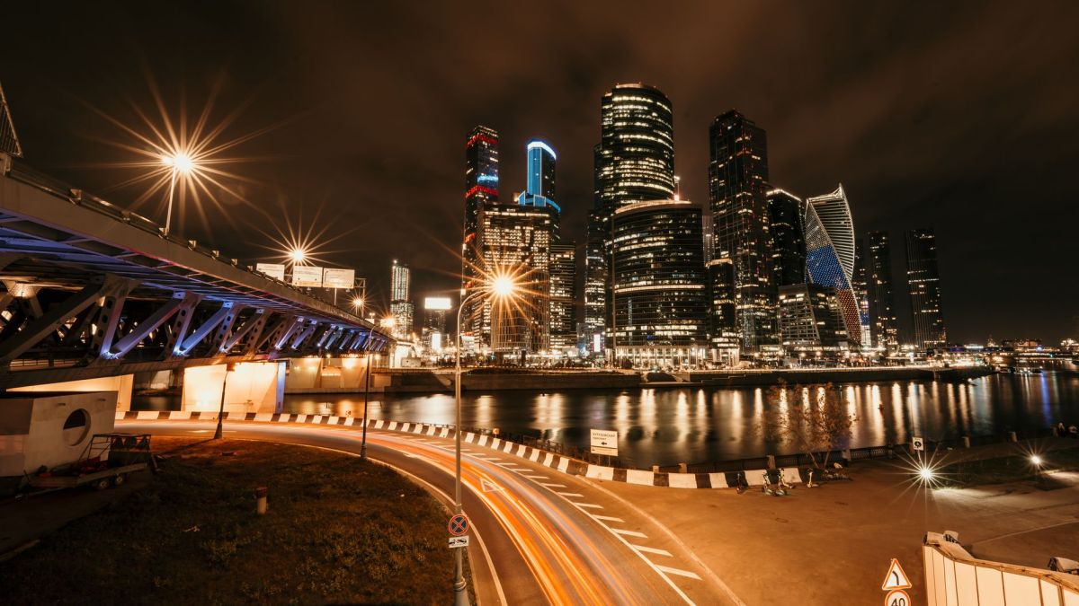 Stunning nighttime cityscape featuring illuminated skyscrapers and a bridge with glowing streetlights.