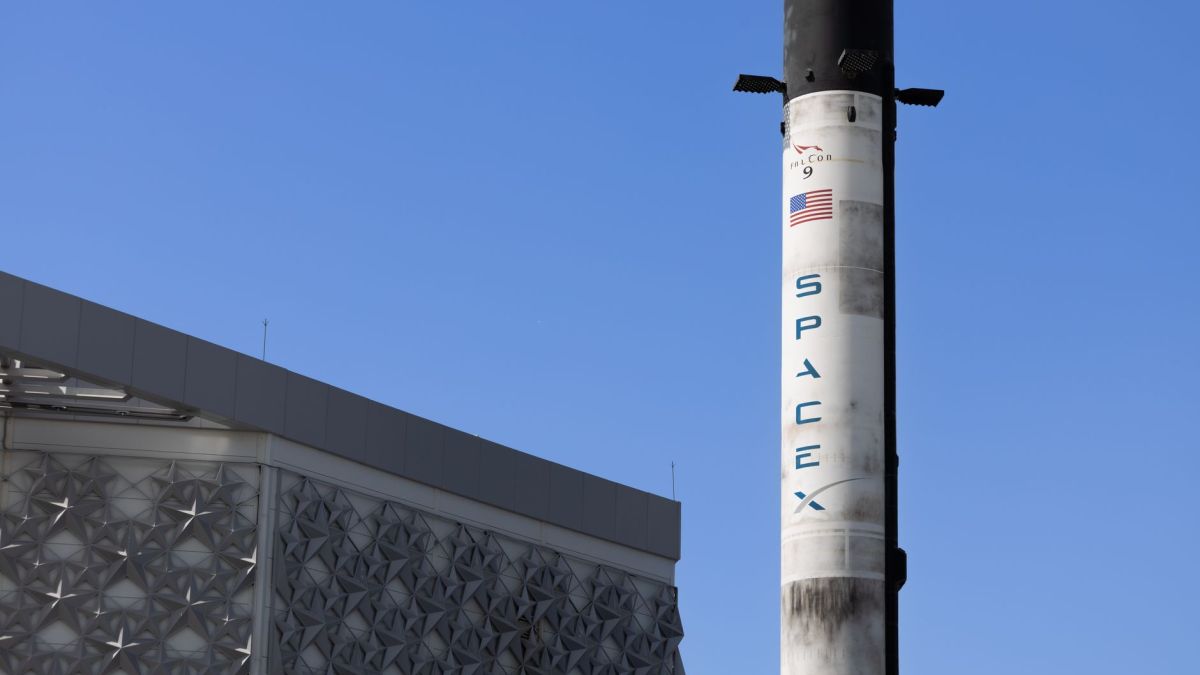 A SpaceX Falcon 9 rocket displayed outdoors against a clear blue sky in Dubai.