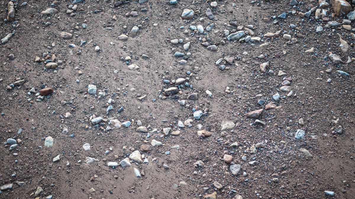 Close-up of natural gravel and pebble ground texture with earthy hues.