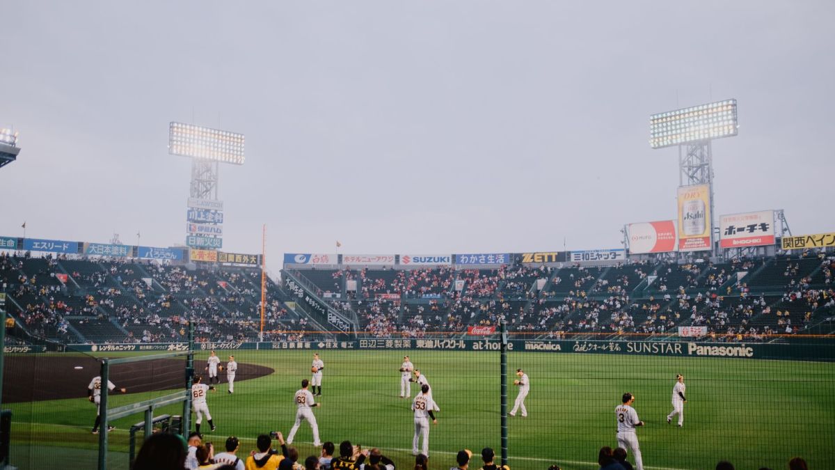 Players and spectators enjoy a vibrant baseball game at Hanshin Koshien Stadium, Japan.
