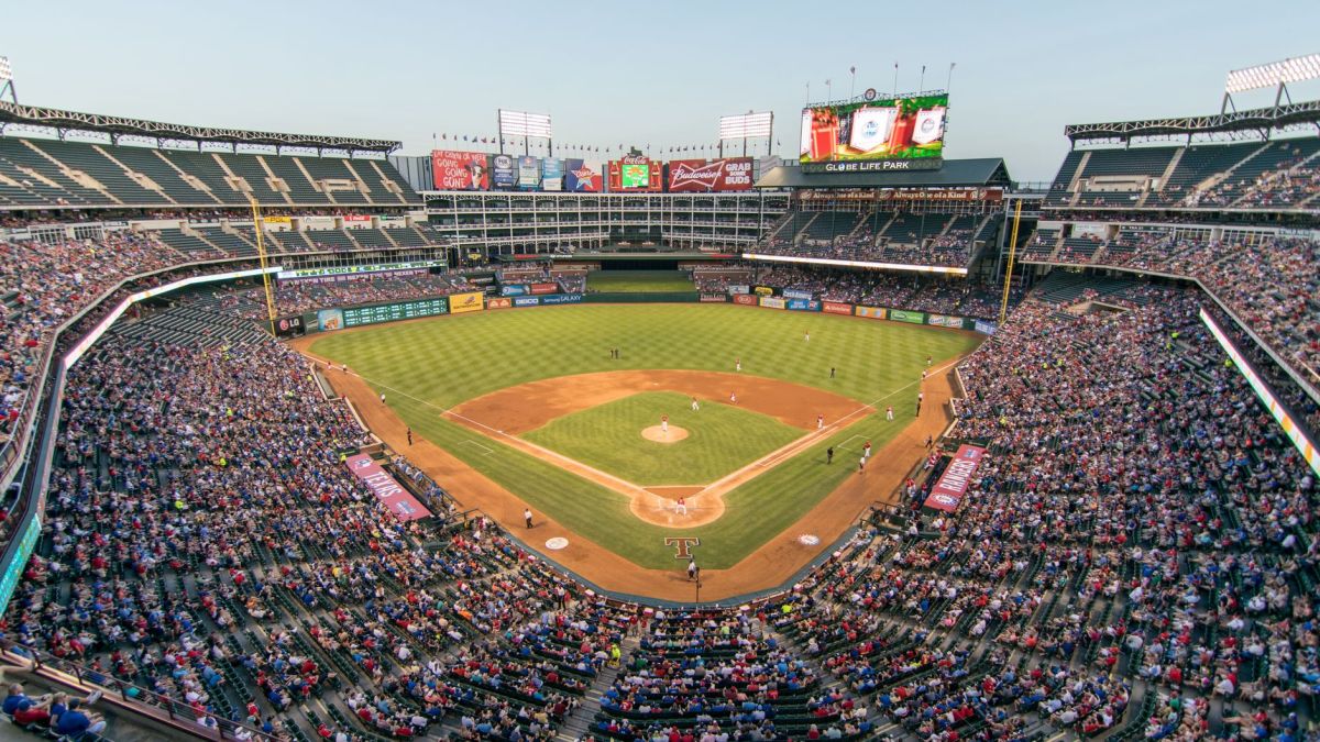 Aerial view of a lively baseball game at the iconic Globe Life Park filled with cheering fans.